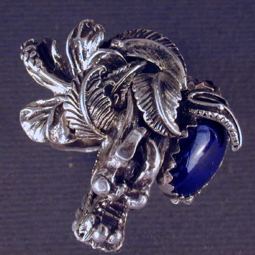 Have powerful dragon wraped around your finger with this large sterling silver ring.  The stone in the one of a kind piece is AA grade lapis.